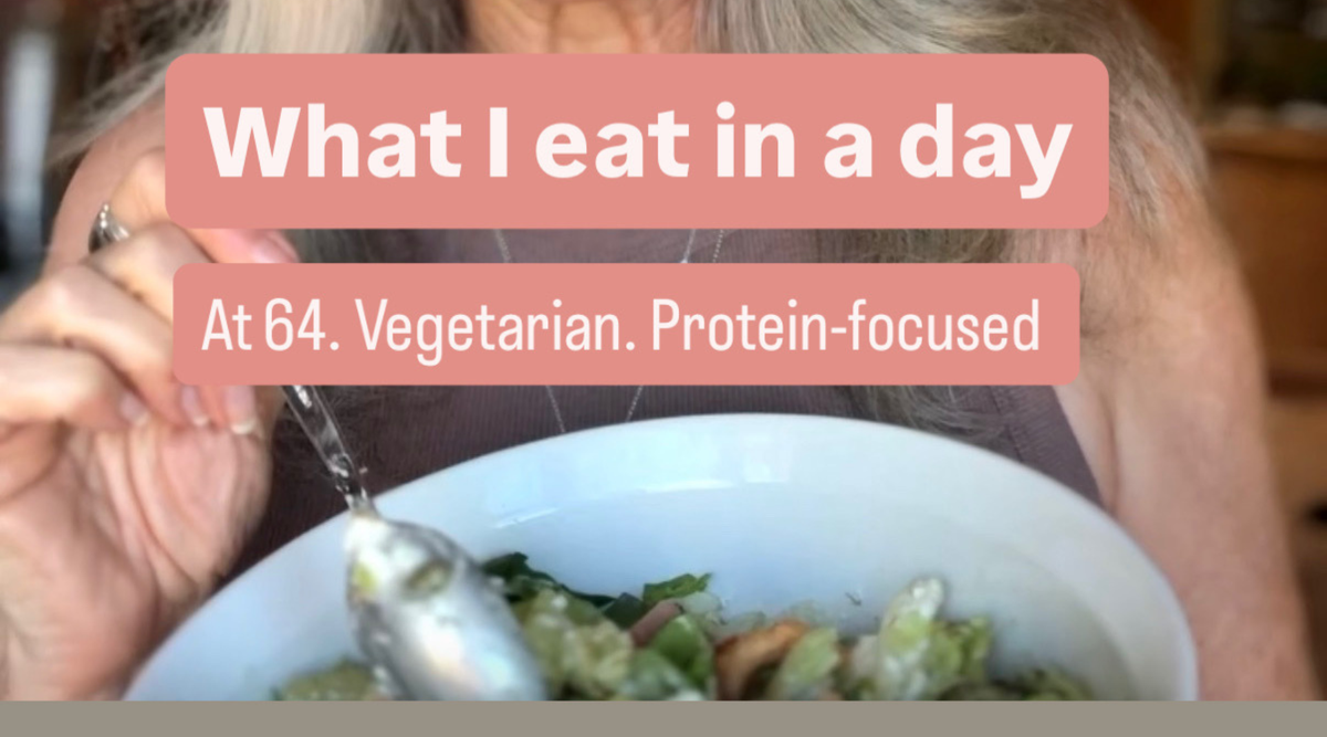 woman holding a spoon over bowl of salad.