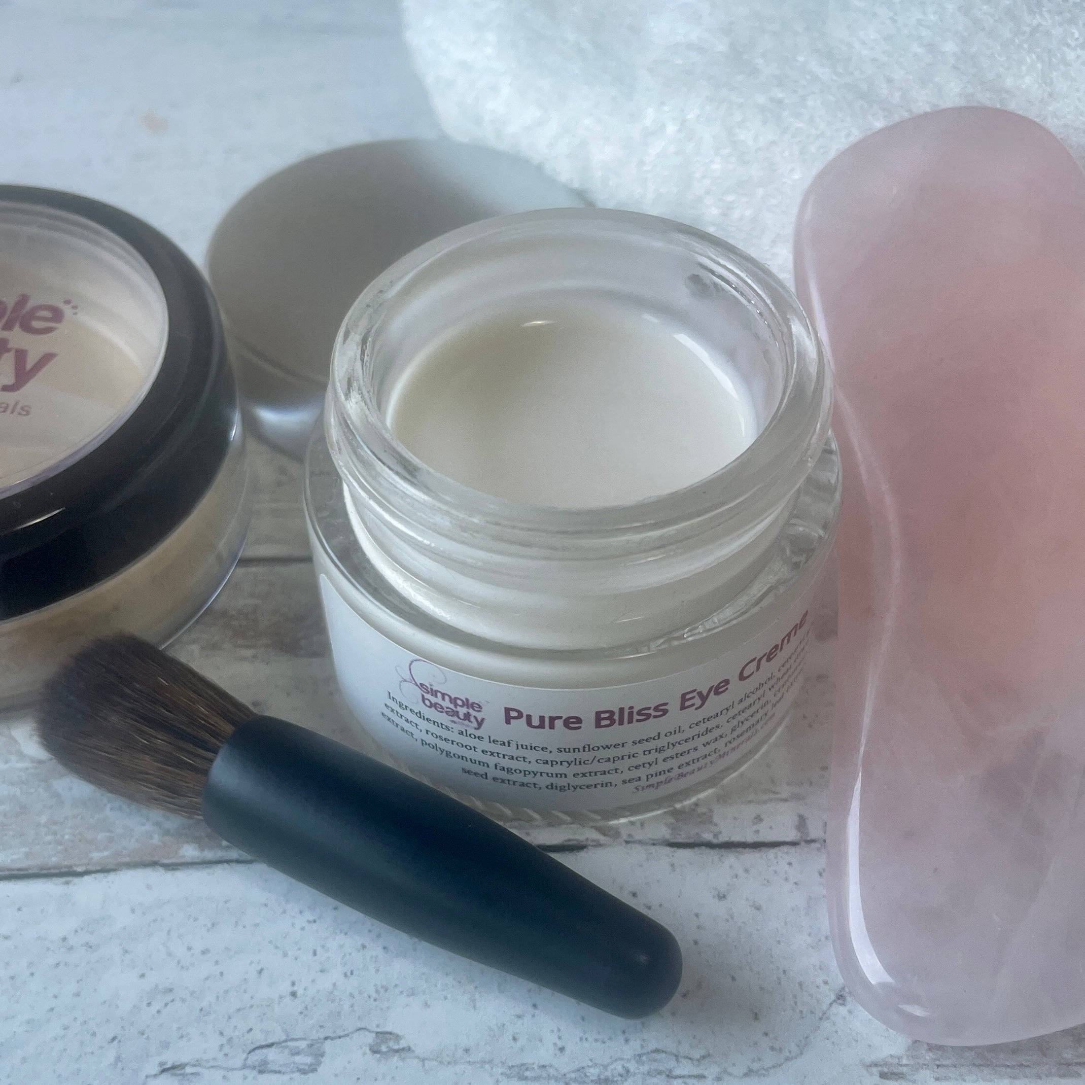 open jar of eye cream with brush.
