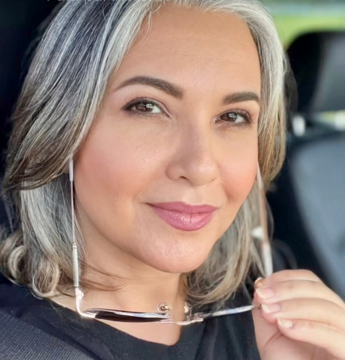 woman wearing foundation holding sunglasses.