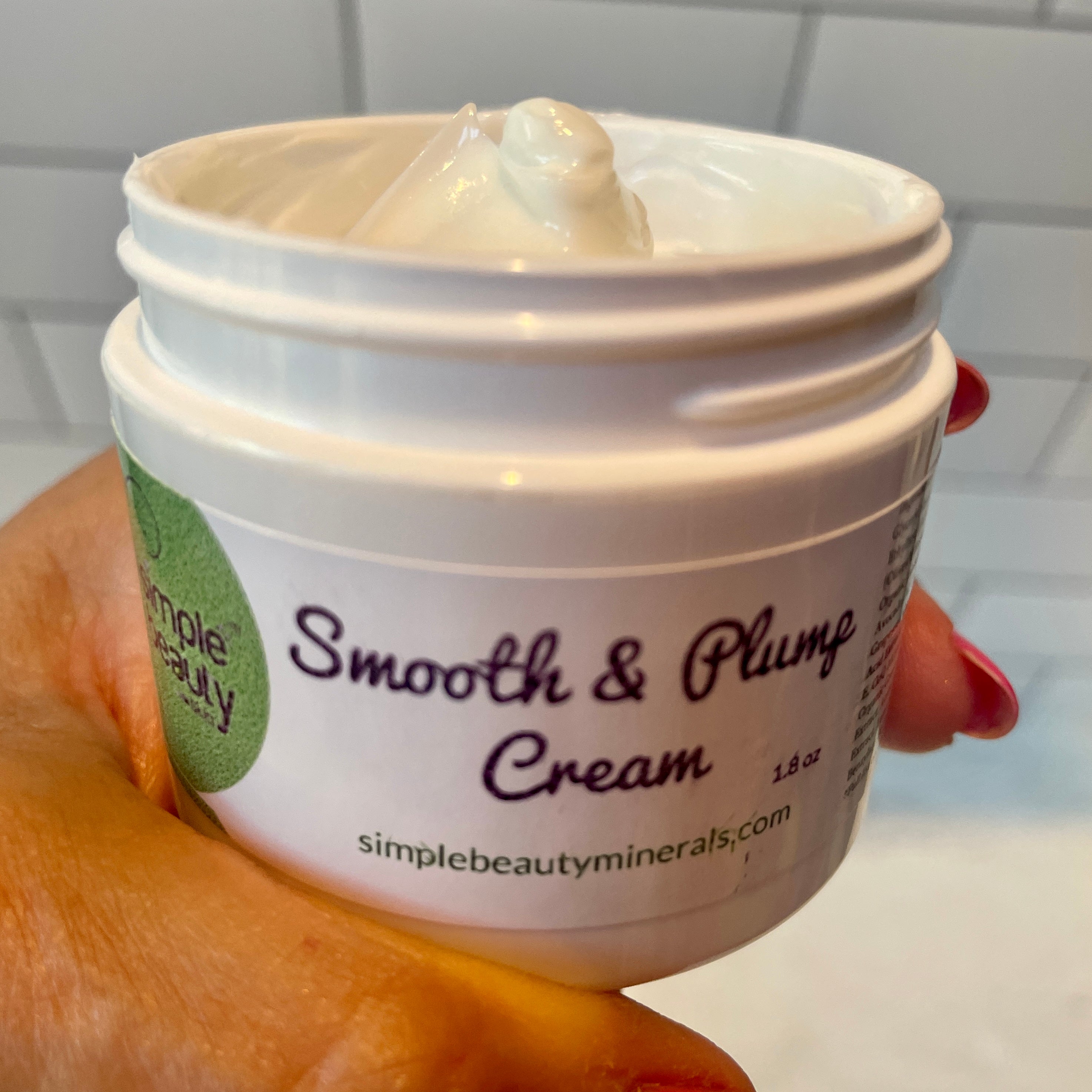smooth and plump cream in hand lid off creamy texture