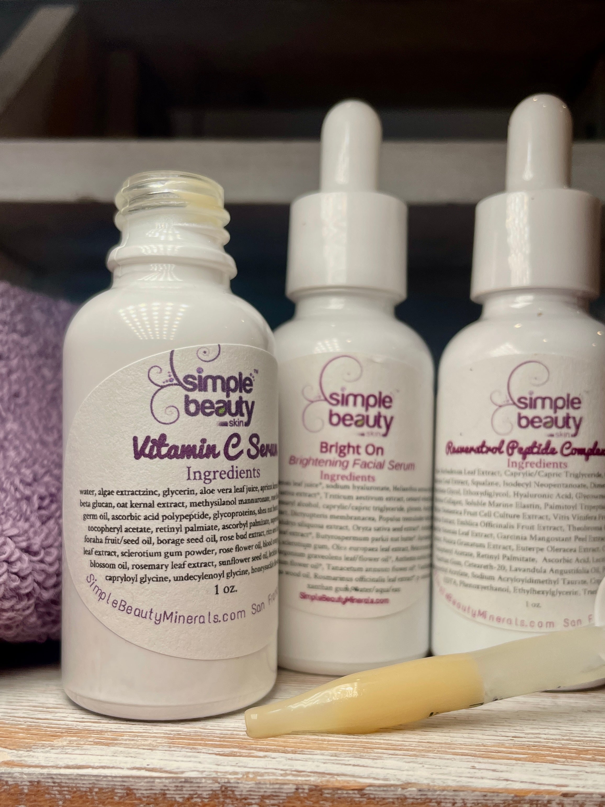 trio of white serum bottles, one open.