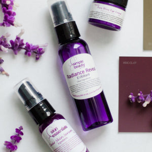 purple skincare bottles with purple flowers clear skin serum and radiance reveal exfoliant