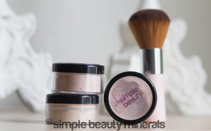 Makeup jars with pink powder brush standing up
