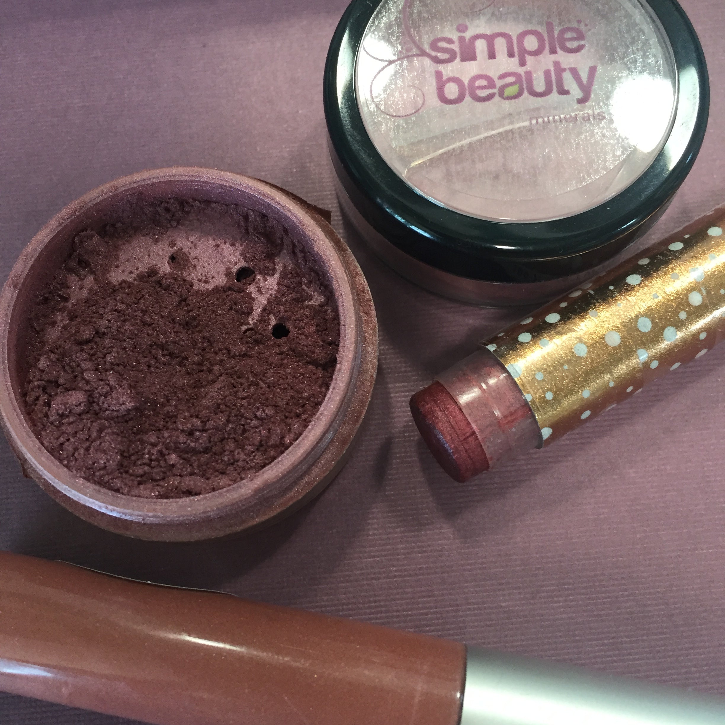 open pot of sumptuous cheek color, lip balm and lip gloss