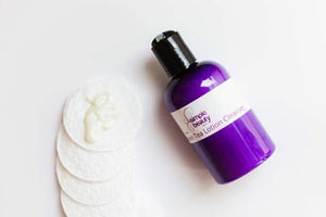 purple lotion cleanser with cotton pads