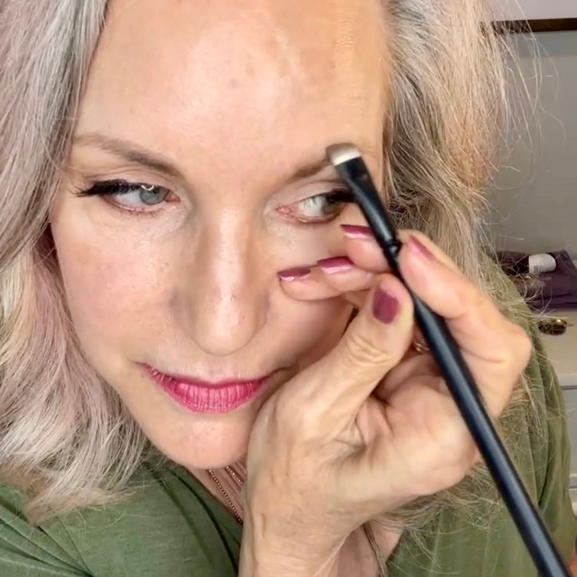owner of simple beauty minerals using brow brush to shape brows