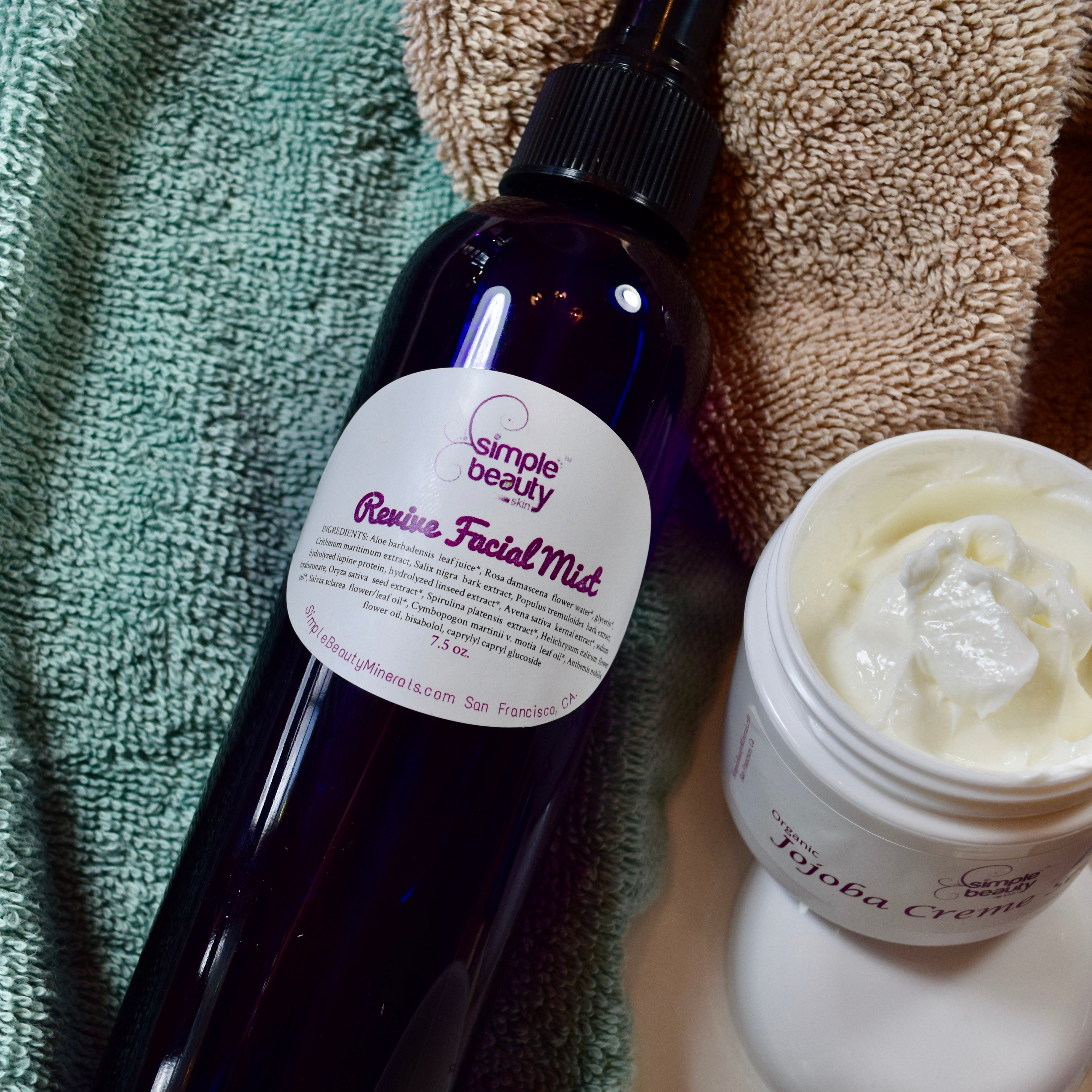 facial mist purple bottle with creme scrub open jar on face cloth