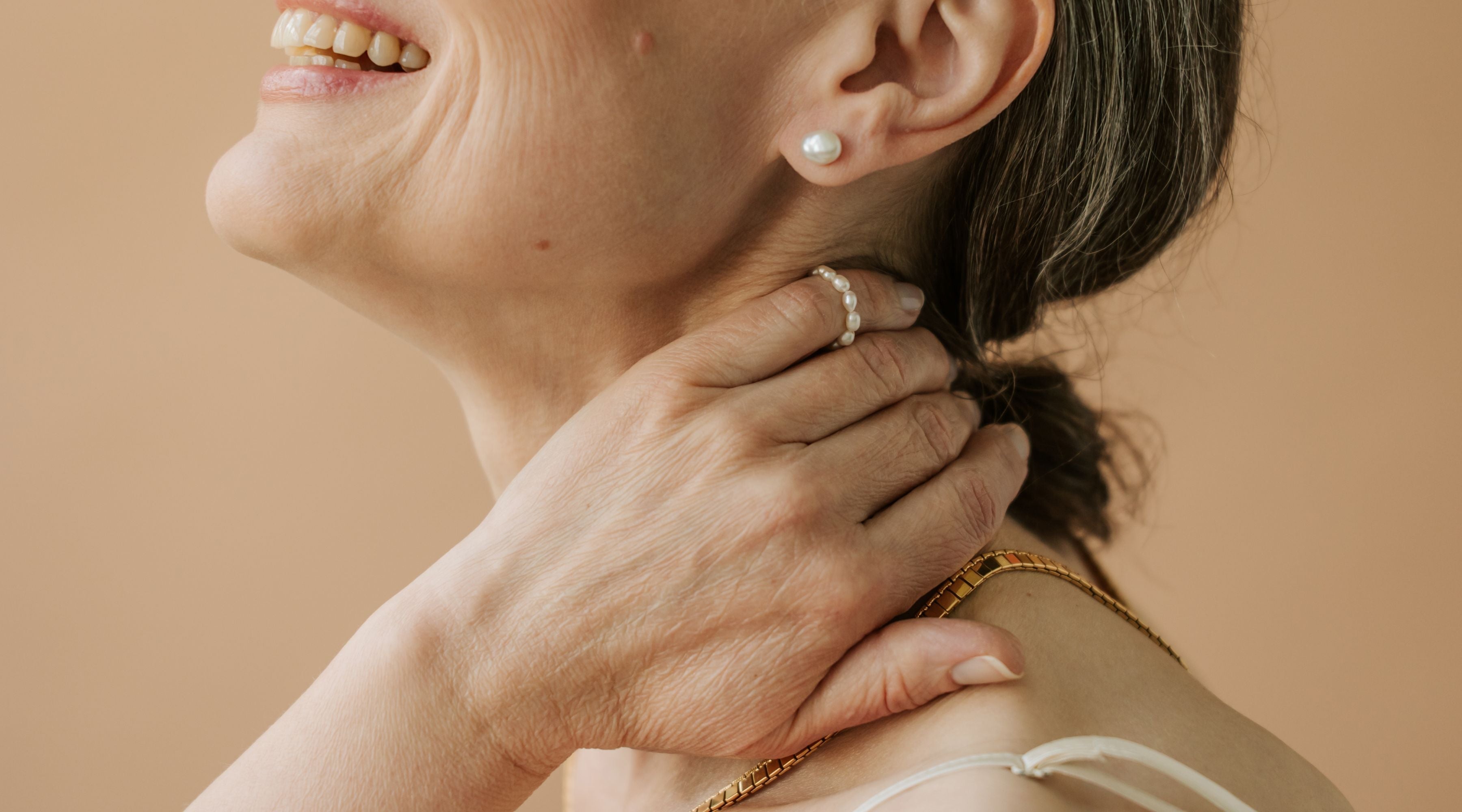 mature woman hands on neck.