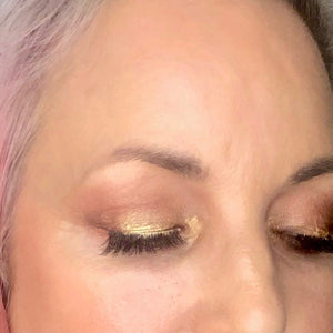 woman's eyes wearing golden glam eyeshadow