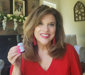 robin from grace filled glam holding vitamin c serum in red top