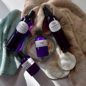 purple skin care bottles on wash cloth and towel